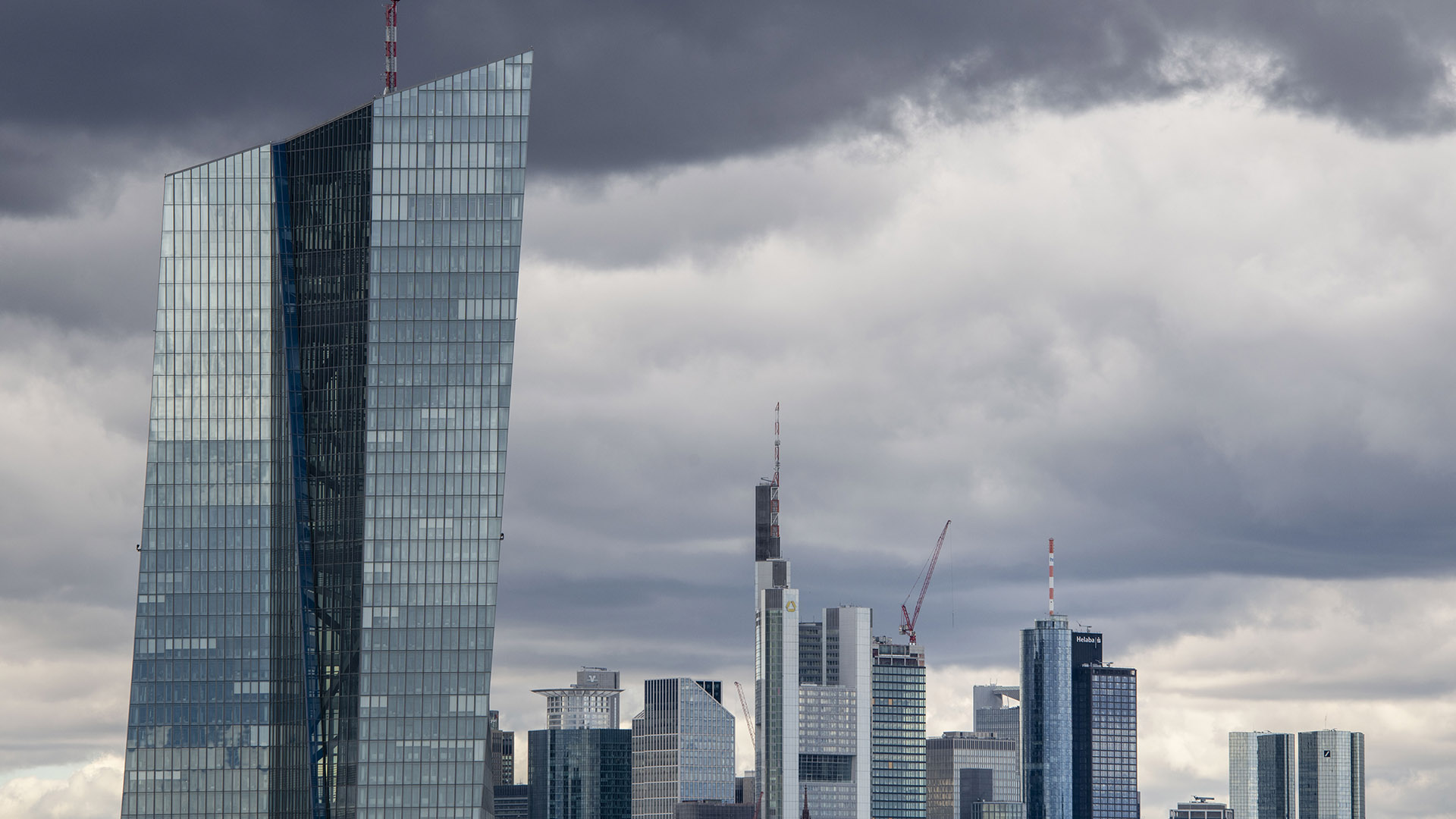 A tall, angular skyscraper against a cloudy city skyline.